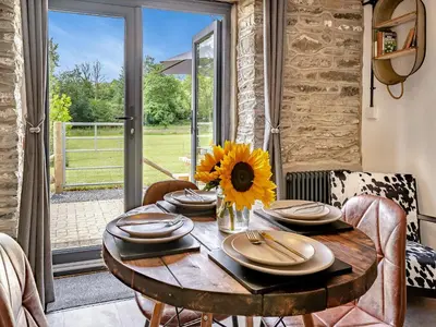 a dining room with a table with a sunflower on it at The Old Cowsheds 3 - Mynach - Uk49788 in Cribyn