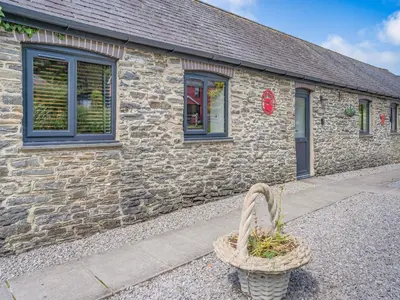 a stone building with a basket in front of it at The Old Cowsheds 2 - Shippon - Uk49787 in Cribyn