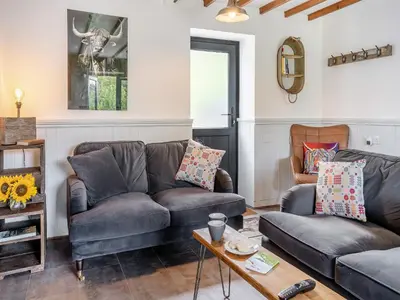 a living room with two couches and a table at The Old Cowsheds 2 - Shippon - Uk49787 in Cribyn