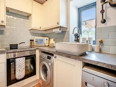 a kitchen with a sink and a washing machine at The Old Cowsheds 1- Dairy - Uk49786 in Cribyn