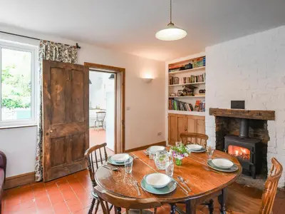 a dining room with a table and a fireplace at Clee View Cottage in Ludlow