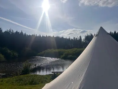 a view of a lake with the sun in the sky at Bell Tent - Lakeside in Oswestry