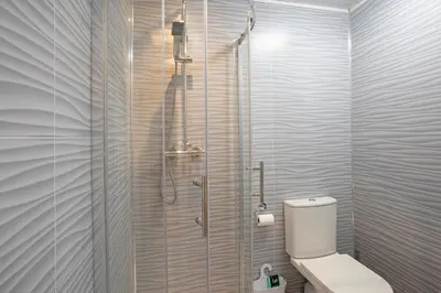a bathroom with a toilet and a glass shower at Scenic Pet Friendly Pod in Talybont Aberystwyth in Aberystwyth