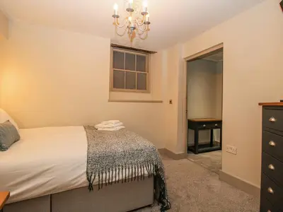 a bedroom with a bed and a chandelier at 1C College Hill in Shrewsbury