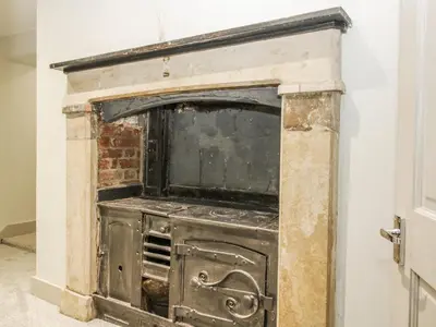 an old stove in the corner of a room at 1C College Hill in Shrewsbury