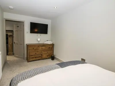 a bedroom with a bed and a tv on a wall at 1C College Hill in Shrewsbury