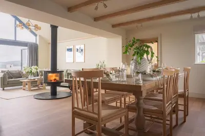 a dining room with a table and a fireplace at Llys y wawr Luxury Holiday Let in Aberystwyth