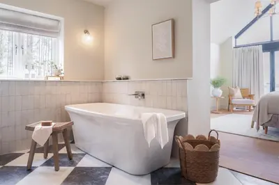 a bathroom with a white tub and a bedroom at Llys y wawr Luxury Holiday Let in Aberystwyth