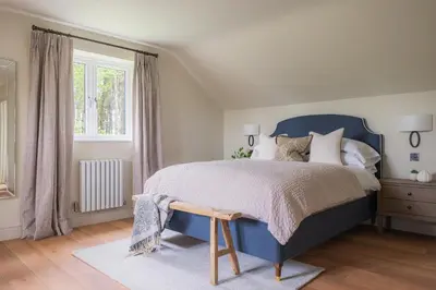 a bedroom with a blue bed and a window at Llys y wawr Luxury Holiday Let in Aberystwyth