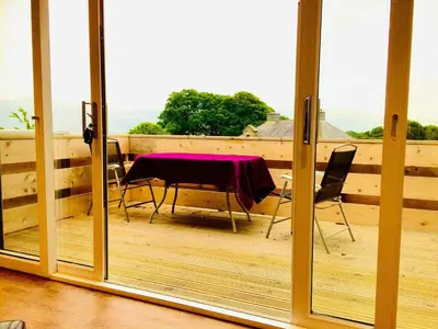a room with a table and chairs on a balcony at Snowdonia 1-Bed Chalet Sleeps 2 Stunning Views in Pennal