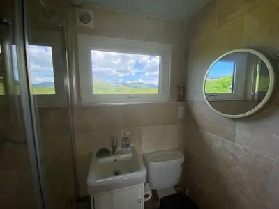 a bathroom with a sink and a toilet and a mirror at Snowdonia 1-Bed Chalet Sleeps 2 Stunning Views in Pennal