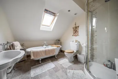a bathroom with a tub and a toilet and a sink at Priory cottage in Clifford