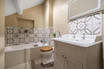 a bathroom with a sink and a toilet and a tub at Priory cottage in Clifford