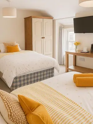 a bedroom with two beds and a desk at Ty Sunnymead Guesthouse in Aberystwyth
