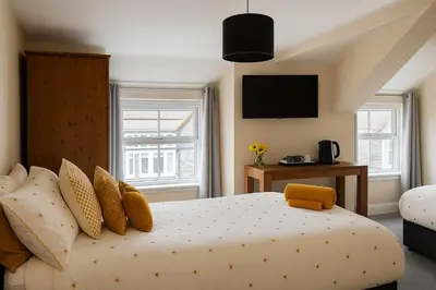 a bedroom with a bed with a television on the wall at Ty Sunnymead Guesthouse in Aberystwyth
