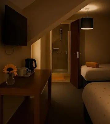 a hotel room with a bed and a table with flowers at Ty Sunnymead Guesthouse in Aberystwyth