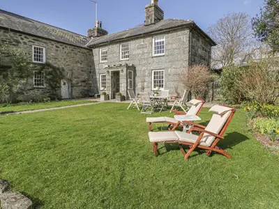 a group of chairs and a table in front of a house at Bwthyn Mawr in Harlech