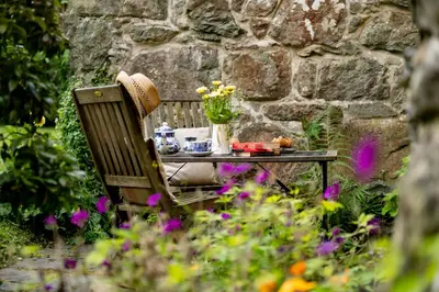 a table and a bench with a table and flowers at Ty Trol in Dolgellau