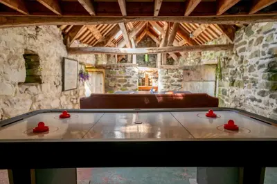 a ping pong table in the middle of a room at Ty Trol in Dolgellau