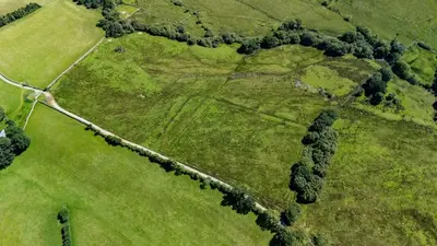 an aerial view of a field with trees and a road at Ty Trol in Dolgellau