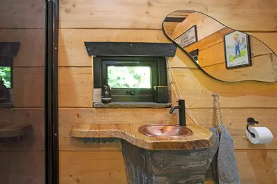 a bathroom with a stone sink and a mirror at Woodcutters' Cabin Authentic Log Cabin Talybont Aberystwyth SY245DW in Aberystwyth