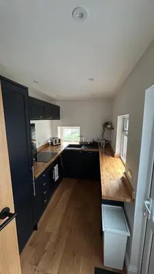 a kitchen with black cabinets and a wooden floor at Builth wells stay in Builth Wells