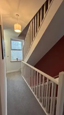 a staircase in a home with a white rail and a window at Builth wells stay in Builth Wells