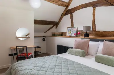 a bedroom with a large bed and a desk at Swn y Nant in Glyn-Ceiriog