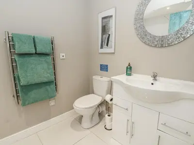 a bathroom with a sink and a toilet and a mirror at Little Penrhosgoch Barn in Llandrindod Wells