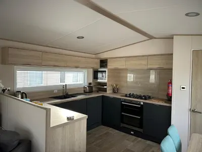 a kitchen with black and white cabinets and a counter at 186 Barmouth Bay Holiday Park in Barmouth