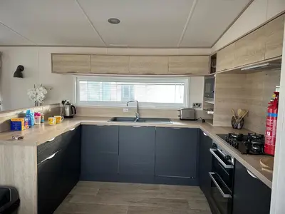 a kitchen with blue cabinets and a sink at 186 Barmouth Bay Holiday Park in Barmouth