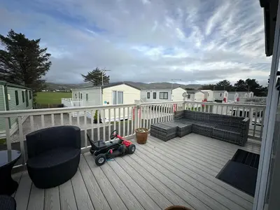 a baby stroller sitting on a deck on a porch at 186 Barmouth Bay Holiday Park in Barmouth