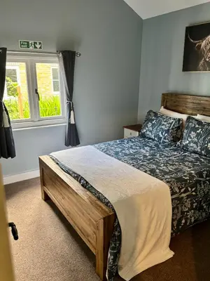 a bedroom with a bed and a window at The Robin, Arrowwood Self Catering in Kington