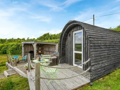 a wooden cabin with a deck and a table at The Owl Pod - Uk50070 in Welshpool