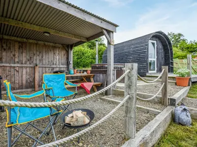 a patio with chairs and a table and a shed at The Owl Pod - Uk50070 in Welshpool