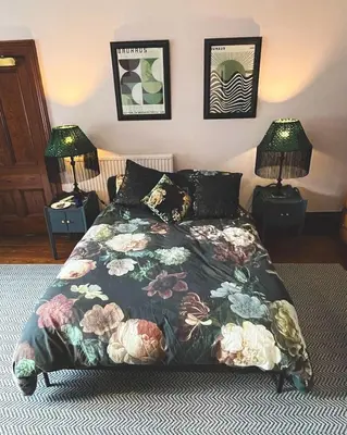 a bedroom with a bed with a floral bedspread and two lamps at Bala Suite at pen Y Coed Hall in Dolgellau