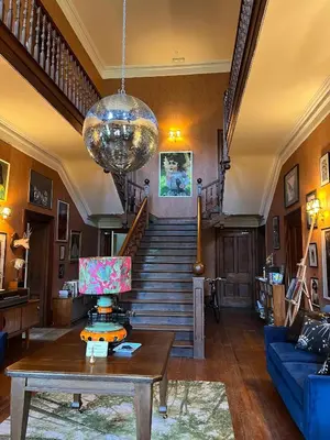 a living room with a table and a staircase at Bala Suite at pen Y Coed Hall in Dolgellau