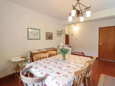 a dining room with a table with a vase of flowers on it at Hafod in Llangollen