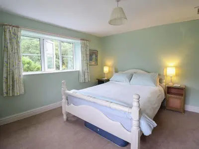 a bedroom with a white bed and a window at Hafod in Llangollen
