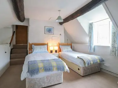 a attic bedroom with two beds and a window at Hafod in Llangollen