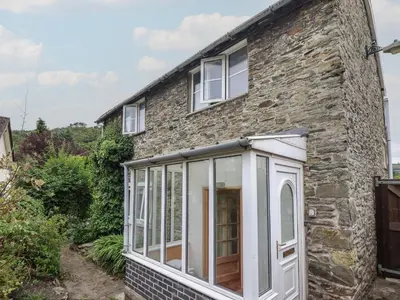 an extension to a stone house with sliding glass doors at Hafod in Llangollen