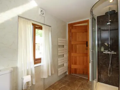 a bathroom with a shower and a glass door at Callow Cottage in Craven Arms