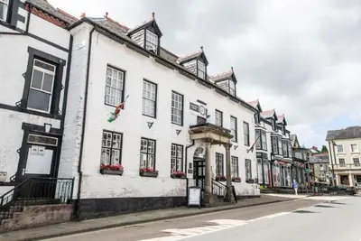 a row of white buildings on a street at Community Owned Gwesty Owain Glyndwr Hotel in Corwen
