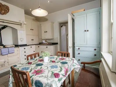 a kitchen with a table with a floral table cloth on it at The Old Vicarage in Leominster