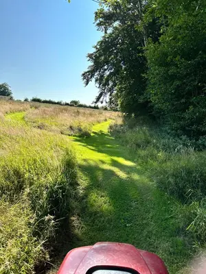 a red car parked in a field of grass at Pencastell Views in Nantcwnlle