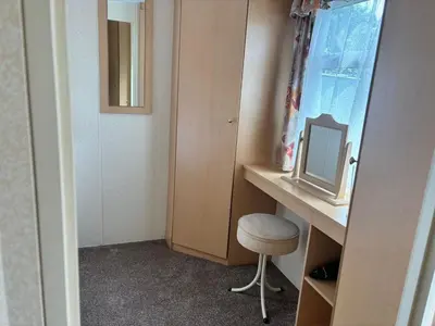 a room with a desk with a stool and a mirror at Cadwgan Caravan No2 in Barmouth