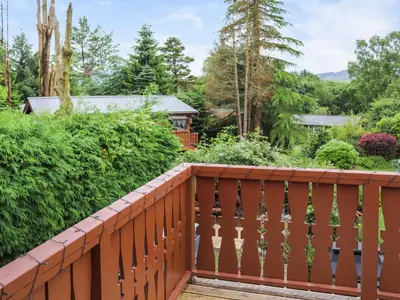 a wooden balcony with a view of a garden at Barken in Trawsfynydd