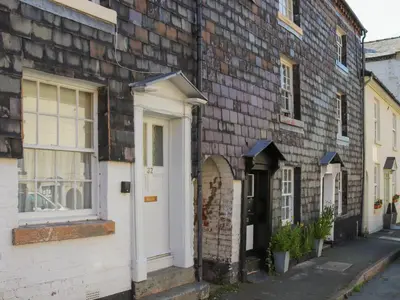 an old brick building with a white door and windows at Crescent Cottage in Newtown