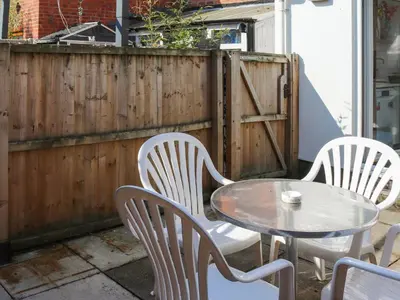 three chairs and a table and a fence at Crescent Cottage in Newtown