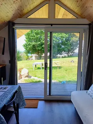a sliding glass door with a view of a field at CABIN 8 Pet friendly Family glamping Seaview in Llwyngwril